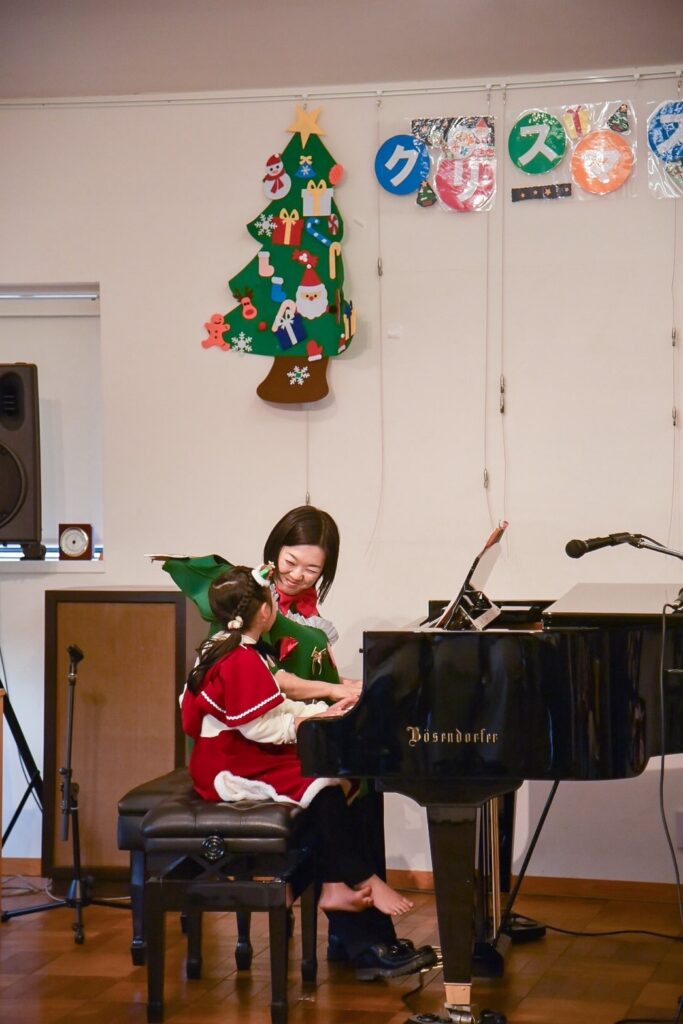    東村山市久米川のピアノ発表会で先生と連弾する子ども